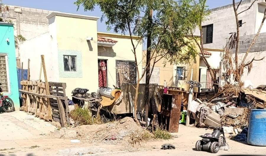 Casa abandonada con escombros y basura en el exterior