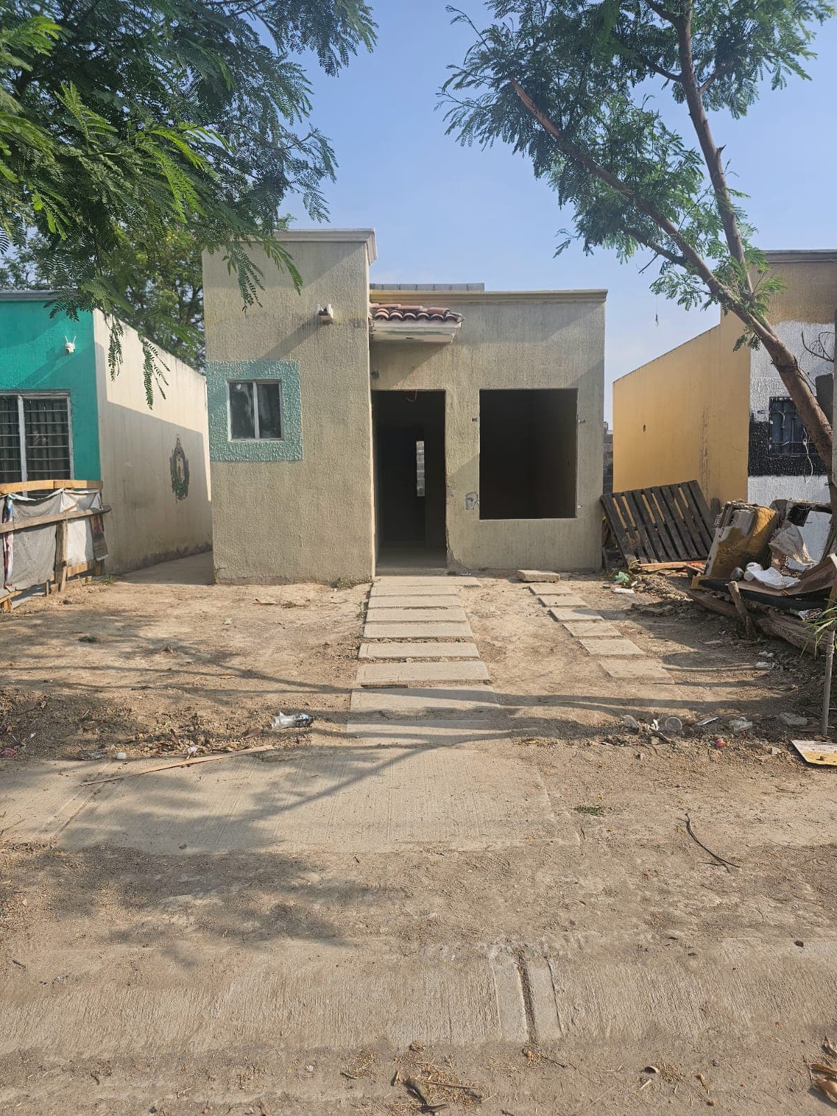 Exterior de la casa recuperada con caminito de losas