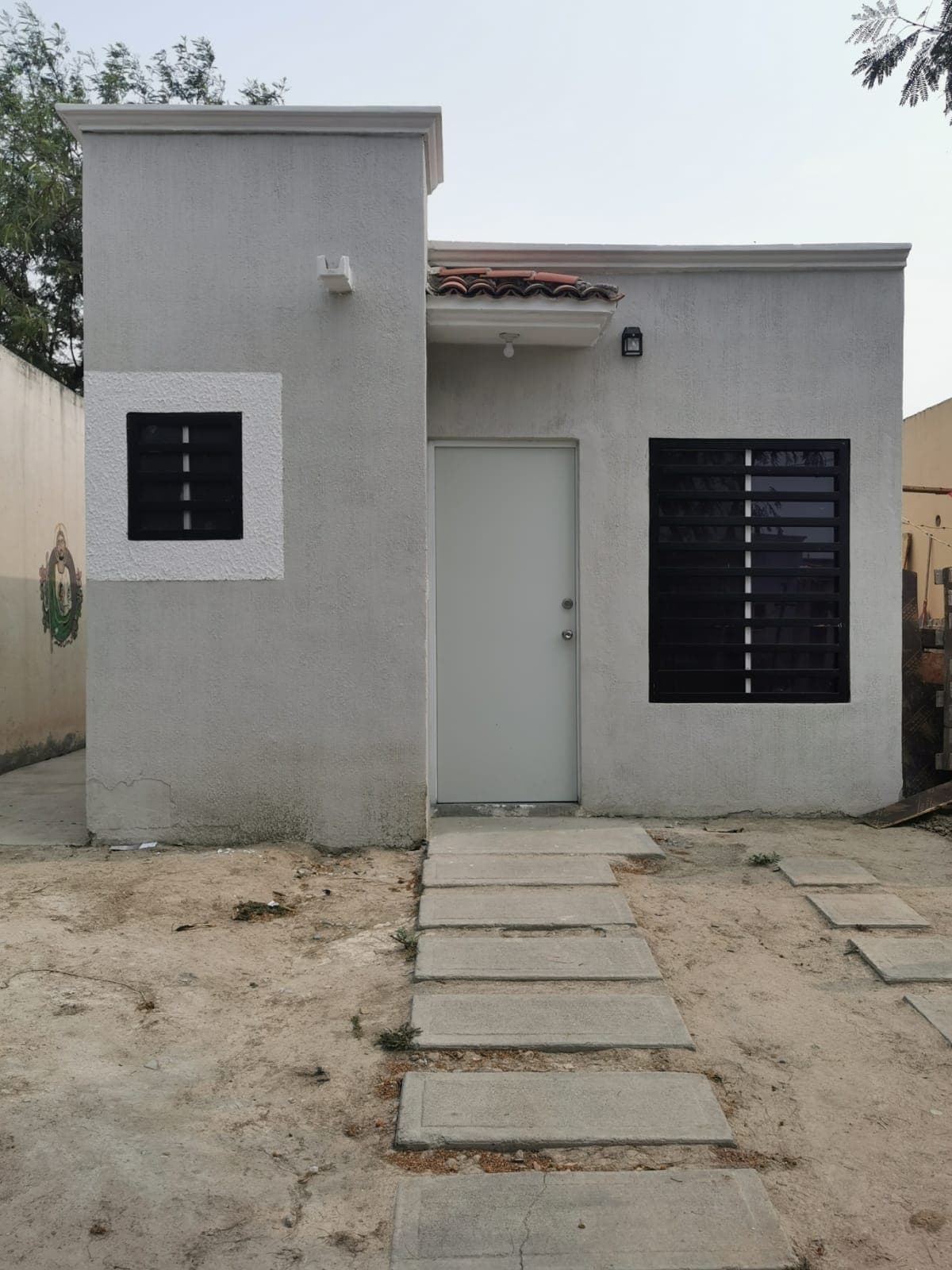 Casa blanca terminada con árboles al frente